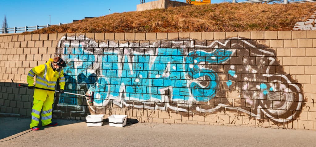 Grafitti på en murvegg blir fjernet av Trøndevask