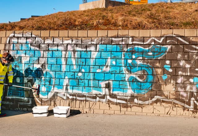 Grafitti på en murvegg blir fjernet av Trøndevask