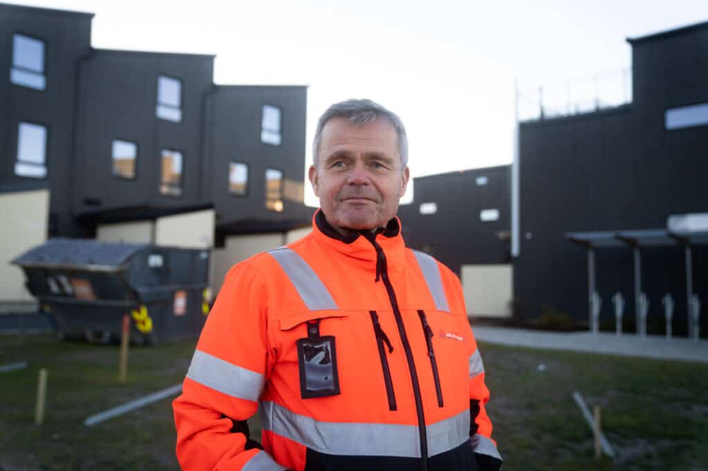 Arnstein Sørgård er byggvask-kunde. Her står han i verneklær med et nybygg i bakgrunnen.