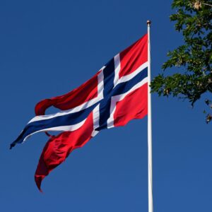 Norsk flagg i toppen av flaggstangen. Flagget vaier i vinden.